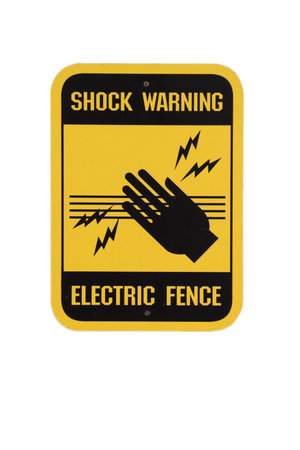 Shock warning sign at electric fence. Yellow and black in white backgroundの写真素材