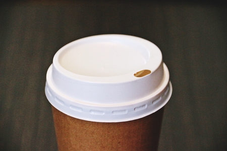 Zoomed to a cap of take away brown cup of coffeeの写真素材