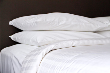 White soft beddding viewed pillows and mattress from bed side