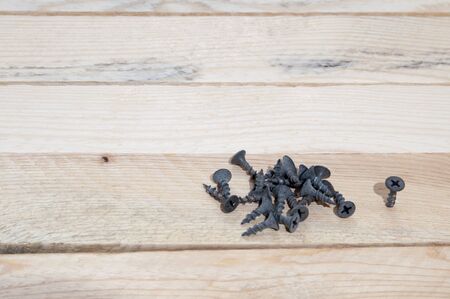 Small screws on a wooden backgroundの写真素材