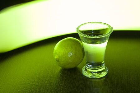 tequila with salt and lime on a green backgroundの写真素材