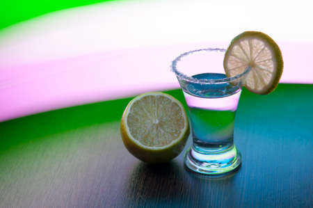 shot tequila with salt, lime slice and lime on the background of colored stripesの写真素材