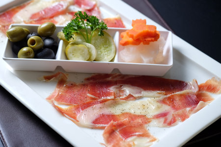Sliced prosciutto ham on plateの写真素材