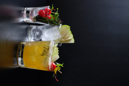 Cocktail on a black background with ice and rosemary.の写真素材