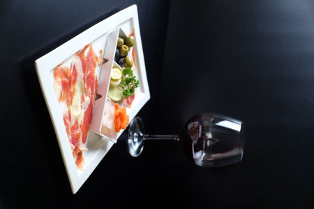 Slices of jamon and olives on a white plateの写真素材