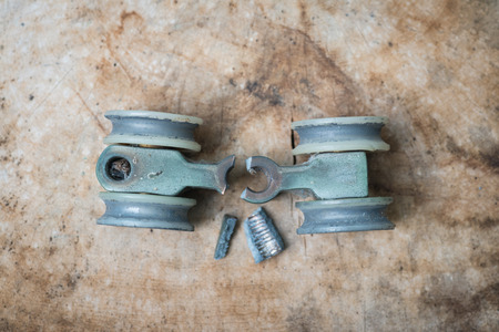 Broken door top roller placed on woodの写真素材