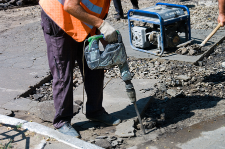 Odessa, Ukraine August 15, 2015: - repair of asphalt pavements and roads in the city center. patch holes in the asphalt on the roadway and the pedestrian. Job asphalt surfacing machinesのeditorial素材