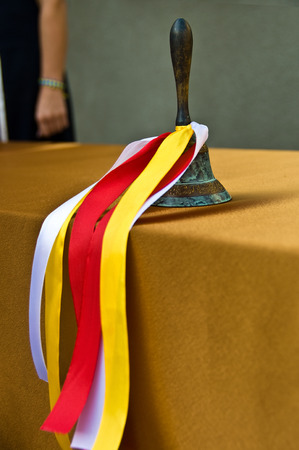 Bronze retro school bell with festive colored ribbons.の写真素材