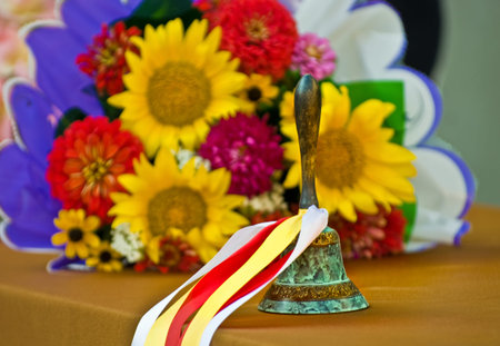 Bronze retro school bell with festive colored ribbons.