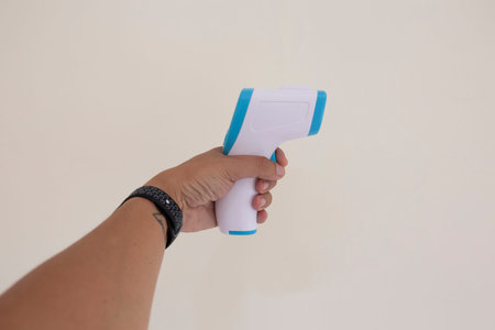 close up of a hand holding a digital infrared thermometer (thermometer gun)の写真素材