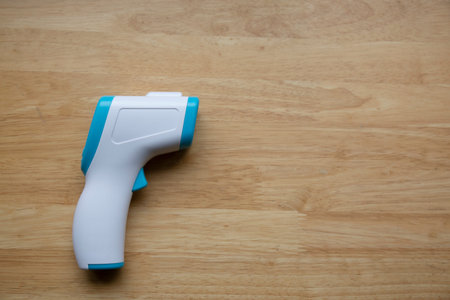 Close up shot of thermometer gun on wooden tableの写真素材