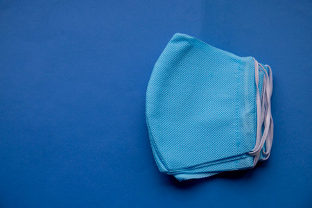 antibacterial medical mask of blue color on a blue background virus epidemic coronavirus protectionの写真素材