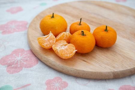 Fresh juicy clementine mandarins on wooden boardの写真素材