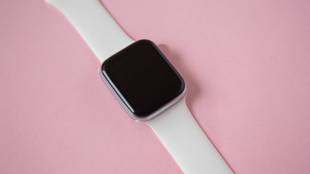 black and white smart watch top view isolated on pink background