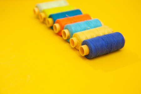 Color sewing threads on yellow background