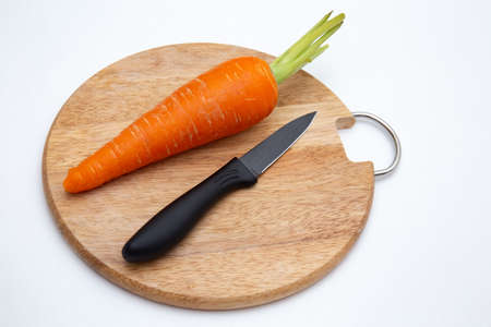 Luxury black kitchen knife and carrot on cutting board isolated on whiteの写真素材