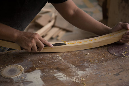a carpenter using a chisel on a block of wood