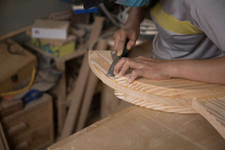 a carpenter using a chisel on a block of woodの写真素材