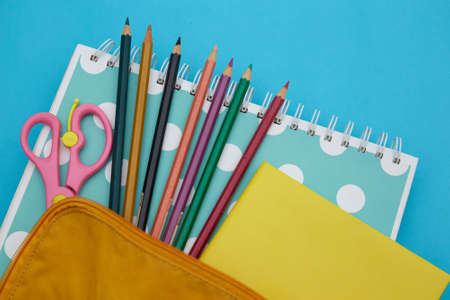 Backpack with school stationery on blue background . Back to school conceptの写真素材