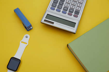 Top view of green book , white pen and school suppliers on yellow backgroundの写真素材