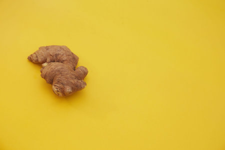 Ginger root on yellow background. Copy space. Flat lay.