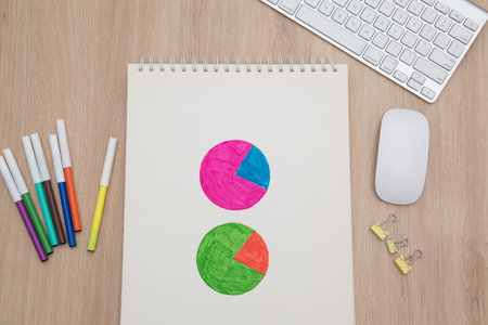 Drawing a graph of growth in a notebook on your desk at home.Wooden work table
