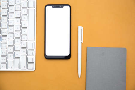 Top view of smartphone , wireless keyboard , pen and notebook on the table . Business conceptの写真素材