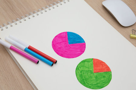 Drawing a graph of growth in a notebook on your desk at home.Wooden work table
