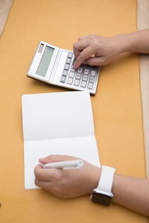 Female Hand Working at home close up shot . Work from home concept . Finance concept. Bill checkingの写真素材
