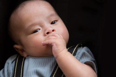 Portrait of Asian baby chewing on his hand