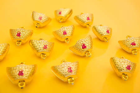 Close-up of gold jingle bells on a yellow background.の写真素材