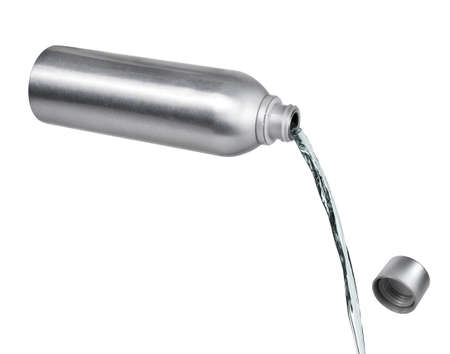 pouring liquid from a metal bottle on white backgroundの写真素材