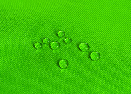 Green waterproof fabric with waterdrops close upの写真素材