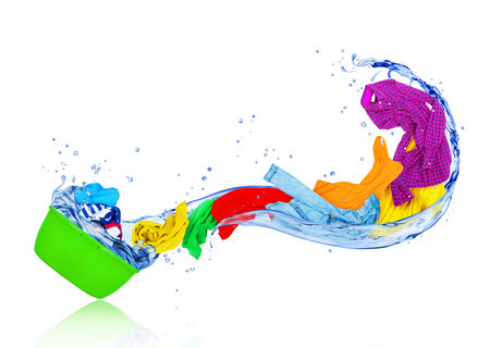Bright colorful clothes flying out from wash bowl with water, isolated on white backgroundの写真素材