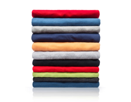 New colored clothing stacked in a pile close-up on white backgroundの写真素材