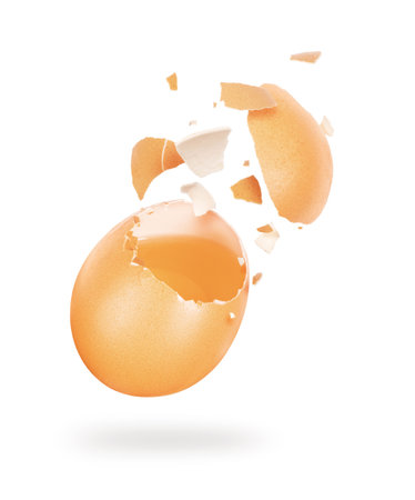 Broken chicken egg hanging in the air on a white backgroundの写真素材