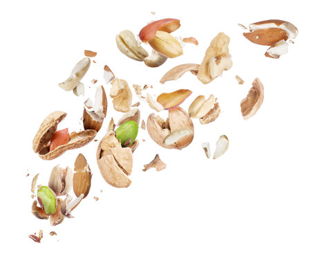 Various nuts crushed in the air on white backgroundの写真素材