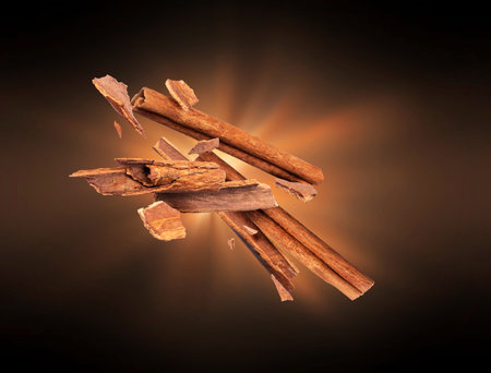 Cinnamon sticks crushed into pieces with flash of light in the dark
