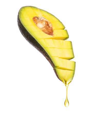 Drop of juice dripping from avocado on a white backgroundの写真素材