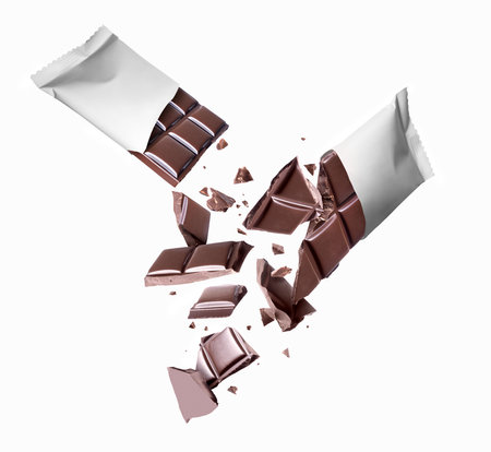 Chocolate bar broken into pieces on a white backgroundの写真素材