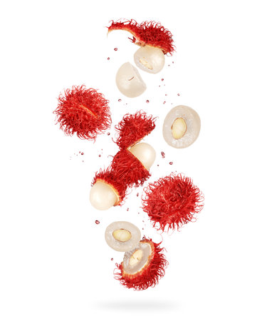 Whole and crushed rambutan fruits in the air, isolated on a white backgroundの写真素材
