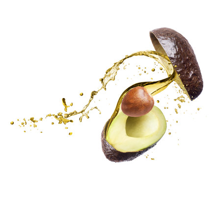 Halves of sliced avocado with splashes of juice close-up on a white backgroundの写真素材