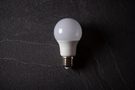 Light bulbs on black stone background