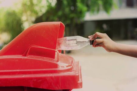 Please dispose of plastic bottle into the tank. A man throw rubbish in the trash can by separate garbage to dispose like hazardous waste  , wet waste, dry waste for reuseの写真素材