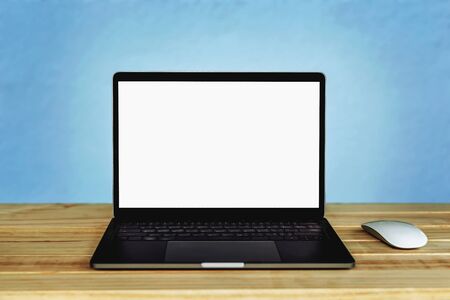 Laptop computer with blank white screen on the table, background wall blurの写真素材