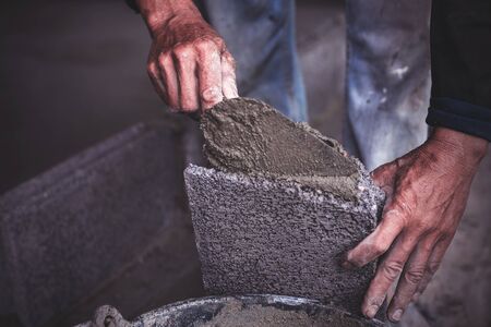 Construction workers are building cement walls with brick blocks.の写真素材