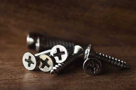 Several screws are placed on the wooden floor.の写真素材