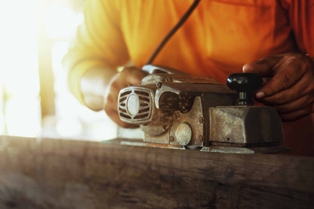 Carpenter is using tools to clear the wood, straighten the wood.