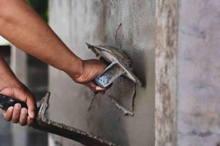 Concrete plasterers to create industrial workers background walls with plastering tools.の写真素材