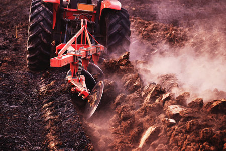 The tractor is tilling the soil, preparing the soil for agricultural farming.の写真素材